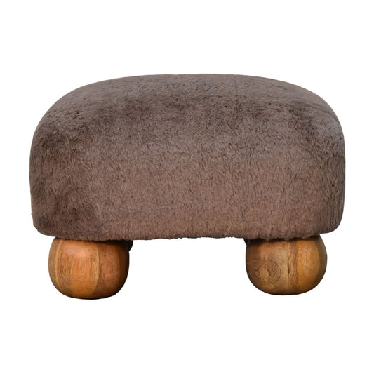 Faux Fur Nordic Footstool styled beside an armchair