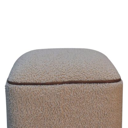 Detail view of the Boucle Footstool's buffalo leather piping