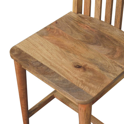 Detail view of the Fringed Dining Chair's solid mango wood grain